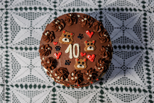 Wallpaper Mural Rich chocolate cake with piped buttercream, teddy bear motifs, hearts, and a bold number ten, displayed on a lace-covered table as a festive celebration centerpiece Torontodigital.ca
