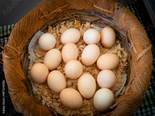 Fresh Farm Eggs in Rustic Wicker Basket, Top View Natural Food Concept. Stock photo.