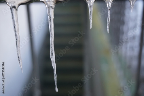 Eiszapfen vor alter Kellertreppe von Haus bei Frost, Eis und Kälte am Mittag im Winter