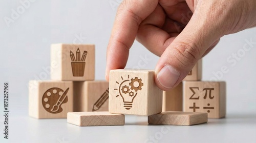 Creative Idea and Innovation: A close-up shot captures the hand carefully arranging wooden blocks featuring symbols representing creativity, innovation, and learning.