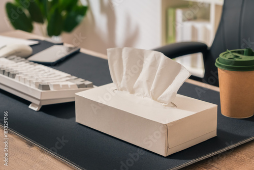 Fényképezés A box of tissues sits on a desk next to a keyboard and a cup