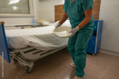 Nurse prepares to assist patient with bedpan in a hospital room setting
