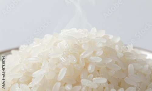Obraz na plátně steaming hot raw white rice plain background lit soft natural light creates sere