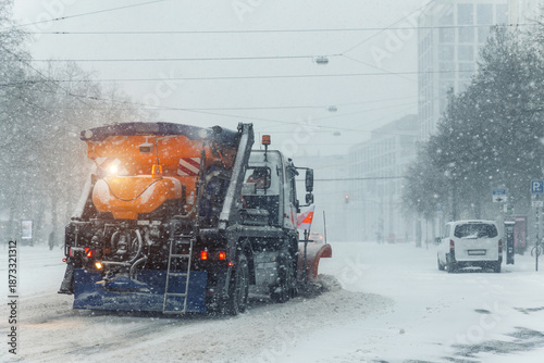 Schilderij op canvas Snowplow truck removing dirty snow from city street on highway during heavy snowfalls