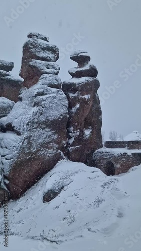 Belogradchik Fortress, an ancient fortress in Bulgaria, located on the northern slope of the Balkan Mountains. Winter view of the fortress and rocks covered with snow, cloudy snowy weather. Winter