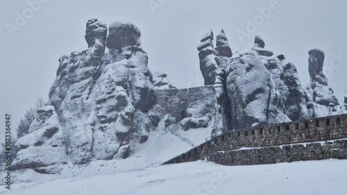 Belogradchik Fortress, an ancient fortress in Bulgaria, located on the northern slope of the Balkan Mountains. Winter view of the fortress and rocks covered with snow, cloudy snowy weather. Winter