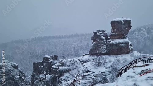 Belogradchik Fortress, an ancient fortress in Bulgaria, located on the northern slope of the Balkan Mountains. Winter view of the fortress and rocks covered with snow, cloudy snowy weather. Winter