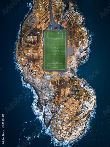 Der berühmte Fußballplatz von Henningsvær in Norwegen eingebettet in die felsige Küstenlandschaft der Lofoten zwischen Meer, Schären und Bergen aus der Vogelperspektive