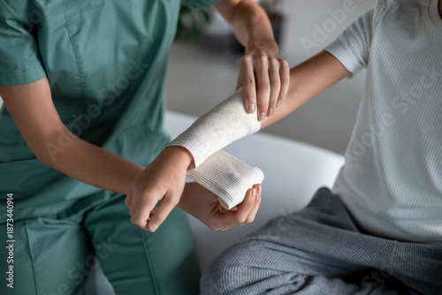 Photos Nurse wrapping bandage around child’s injured arm