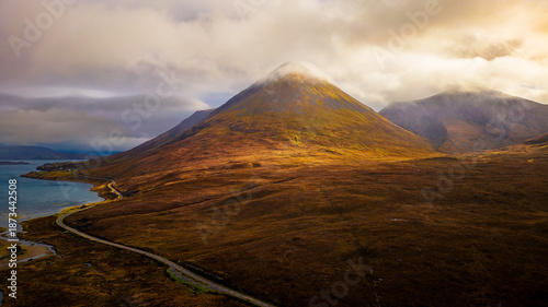 Drone view of Sligachan Bridge with road leading toward Glamaig on Isle of Skye, diffused daylight, dramatic mountain landscape with copy space, iconic Scotland scenery