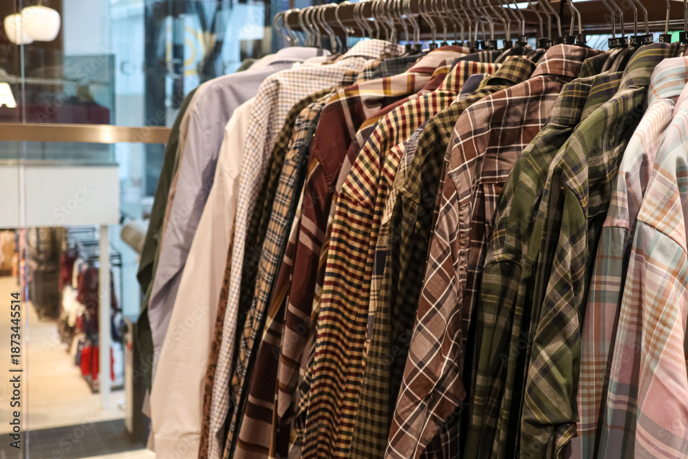Obraz premium Checked shirts on hangers, presenting fashion apparel and consumer retail choices in a modern boutique environment