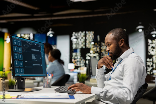 Fotografi Smart AI assistant displayed on a computer monitor helping black man complete tasks at night, power of machine learning to streamline digital interactions and enhance web based connectivity