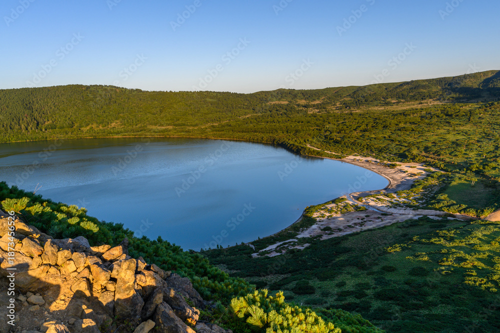 Naklejka premium Serenity of a calm lake surrounded by lush greenery in Russia