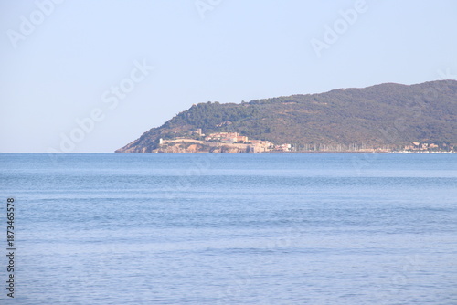 Beautiful scenic view of a wild and empty sandy beach in Albinia, Maremma region, Grosseto province, Tuscany, Italy. Blue sea and Mediterranean coastline under a clear sky.