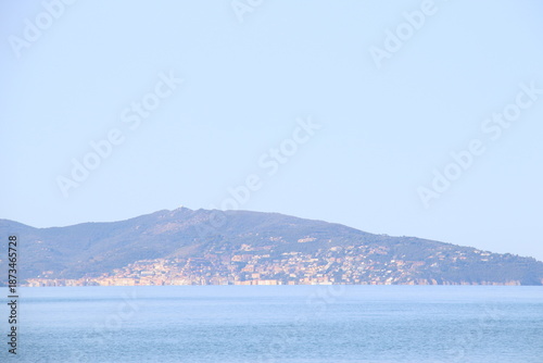 Beautiful scenic view of a wild and empty sandy beach in Albinia, Maremma region, Grosseto province, Tuscany, Italy. Blue sea and Mediterranean coastline under a clear sky.