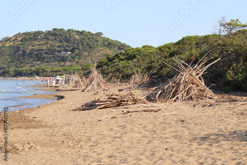 Beautiful scenic view of a wild and empty sandy beach in Albinia, Maremma region, Grosseto province, Tuscany, Italy. Blue sea and Mediterranean coastline under a clear sky.