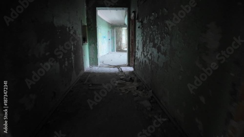 Crumbling walls and debris litter the floor of a decaying hallway, remnants of the once-popular Medea Sanatorium in Tskaltubo, Georgia, a relic of the Soviet era abandoned after the USSR's collapse
