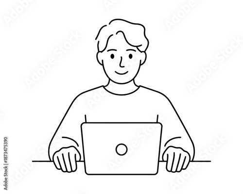 A smiling man sitting at a desk and working on his laptop computer
