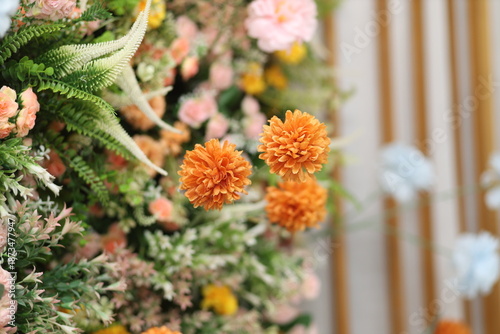 Foto Beautiful artificial orange marigold flowers arrangement with green leaves for wedding party decoration backdrop