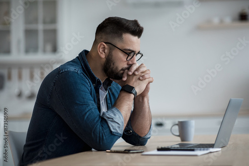 Valokuva Focused male using internet service, writing email, searching information, study remote