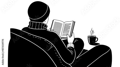 A person relaxing on a couch reading a book with a steaming cup of coffee beside them in a cozy environment