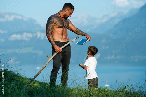 Obraz na plátně Farmers father and his son work together on summer farm field