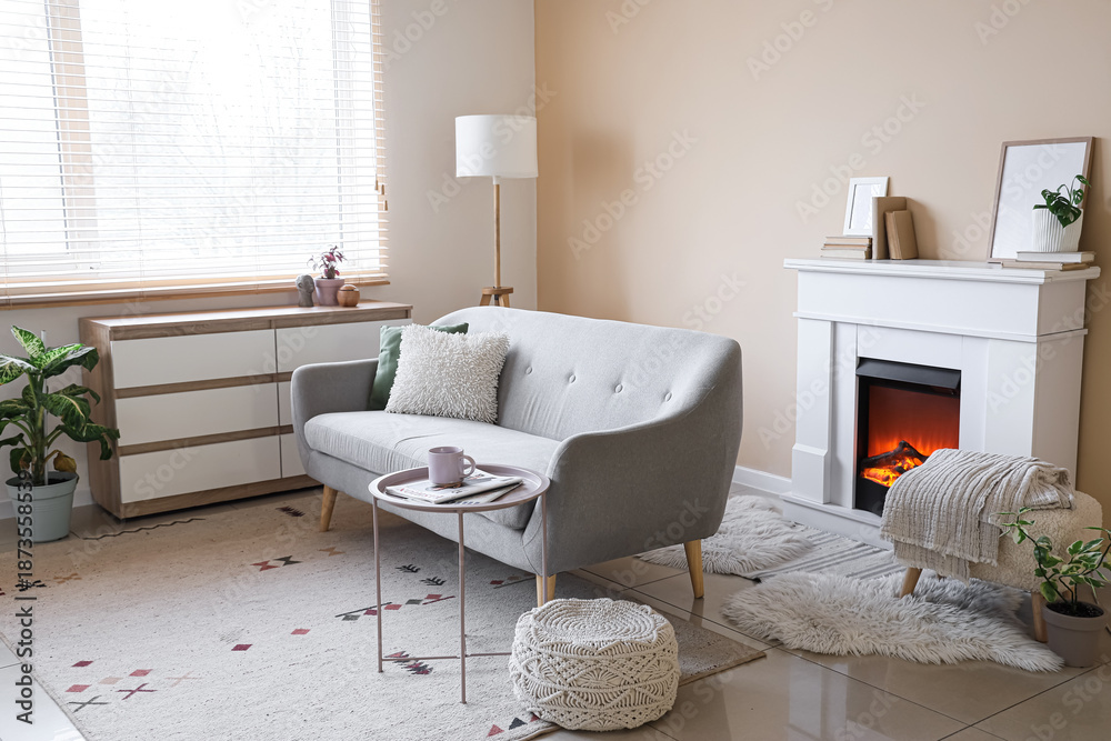 Naklejka premium Interior of living room with grey sofa, commode and fireplace