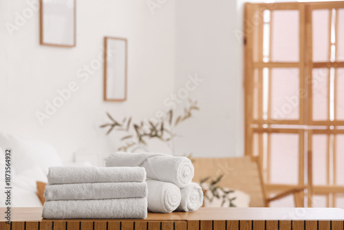 Clean towels on shelf in be...