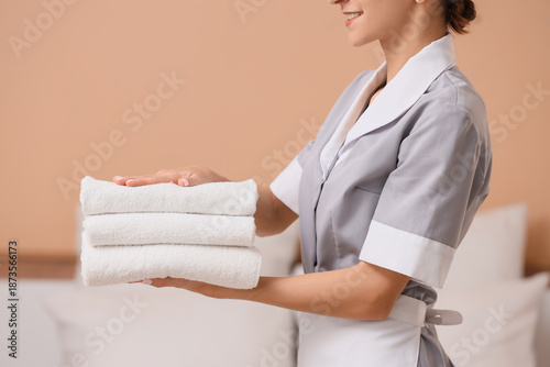 Young chambermaid with stac...