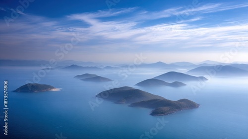 Archipelago of small islands blurred against a soft blue sky with wispy clouds