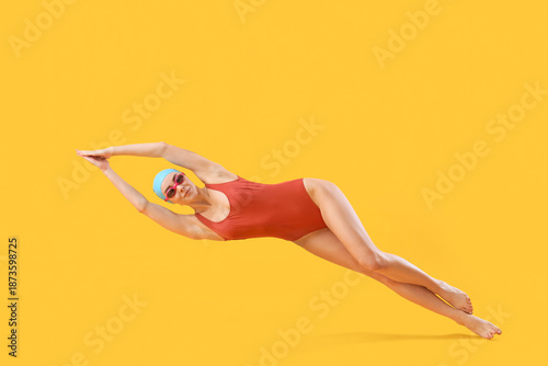 Female swimmer lying on yel...