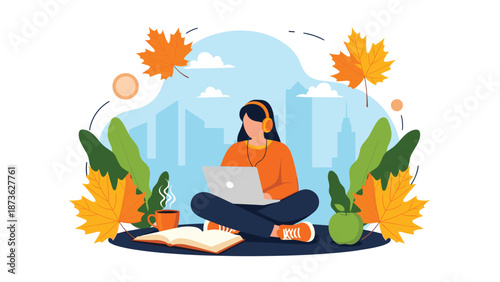 Young woman with headphones works on a laptop while sitting outdoors surrounded by colorful autumn leaves and city buildings.