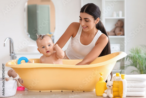 Young mother bathing her li...
