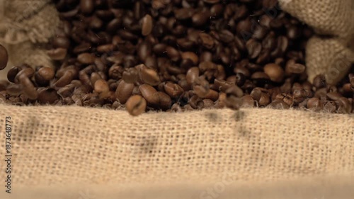 Super slow motion Animated visualization showing coffee beans dropping amidst intricate jute and grain surface