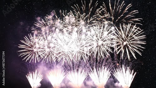 Vibrant green and gold fireworks exploding in night sky with starry background for celebrations