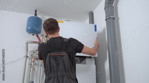 Technician open control panel with internal wiring to inspecting heat pump unit. Specialist servicing heating and cooling system. Concept of HVAC maintenance, home heating system and energy efficiency