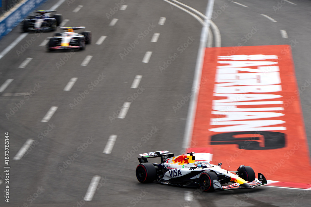 Fototapeta premium BAKU, AZERBAIJAN - SEPTEMBER 20, 2025: RB Formula 1 car navigates a high-speed turn over the distinctive AZERBAIJAN GP track branding during the qualifying session for the 2025 Azerbaijan Grand Prix