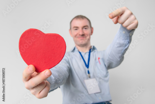Smiling cardiologist doctor holding a healthy heart in his hands