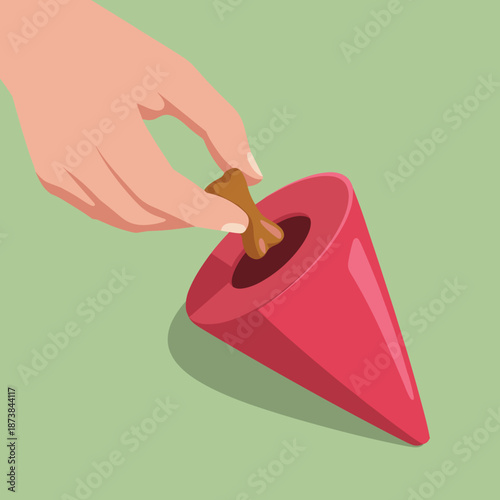 Close up of a human hand placing a bone shaped treat into a red cone shaped rubber dog toy for mental stimulation and enrichment.