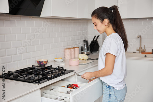 Foto Woman organizing her modern kitchen, tidying up after preparing a meal