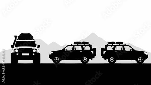 Three Off Road Vehicles Silhouetted Against Mountains.
