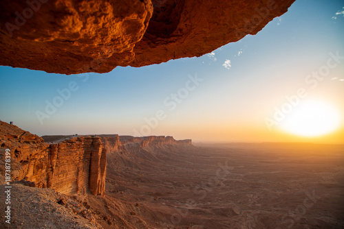 Photos Sunset over desert canyon from rock overhang, dramatic wide landscape of the Edg