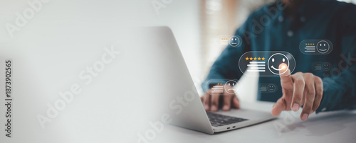 Business Evaluation and Positive Review , Man is using a laptop, pointing at a virtual happy face and five-star rating icon on a customer satisfaction survey interface.