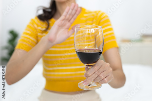 Fotografie Women refusing glass of red wine with hand gesture, concept of alcohol rejection, healthy lifestyle, sobriety or self control