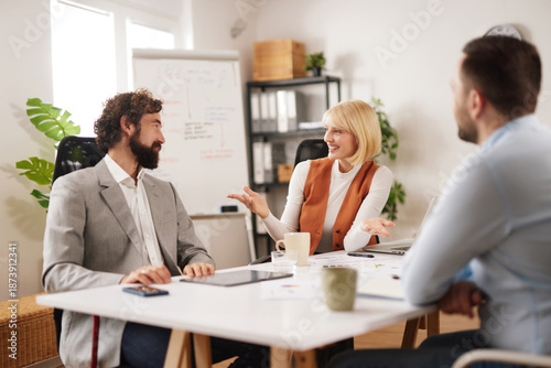 Tableau sur toile People in a modern office engage in a team meeting, sharing ideas and strategies