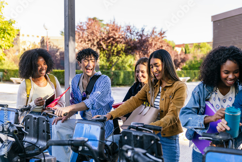 Slika na platnu Group of diverse university students laughing and preparing to ride rental e bik