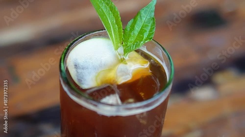 Iced coffee mixed with lemon and mint, creating a refreshing modern beverage with citrus aroma.