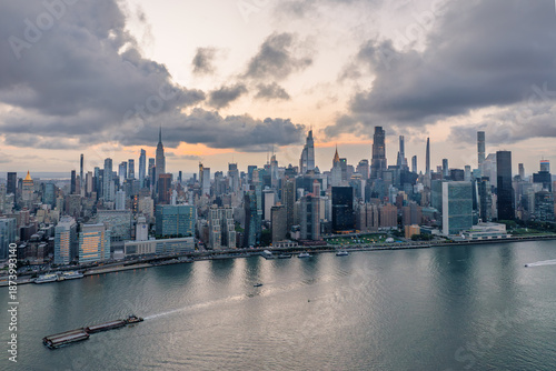 Wallpaper Mural Aerial view of a vast cityscape with towering skyscrapers including the Empire State Building under a dramatic sky, New York, New York, United States. Torontodigital.ca