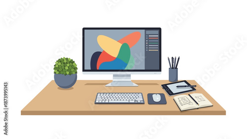 A modern workspace featuring a computer monitor displaying a colorful graphic design on a wooden desk with office supplies and a small potted plant.