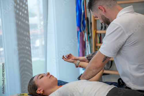 Physiotherapy treatment on a young woman’s shoulder in a professional clinic
